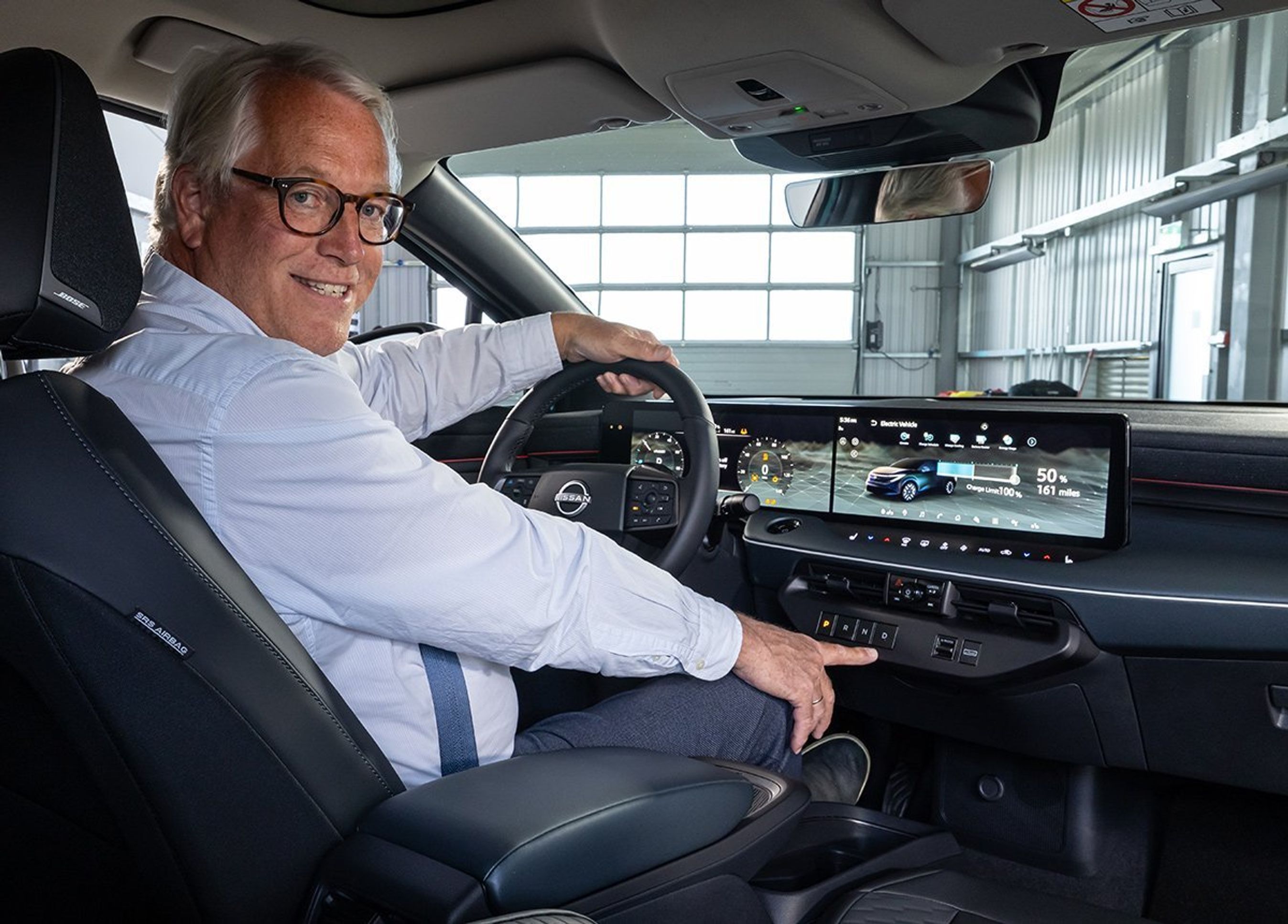 Mand bag rattet af Nissan Leaf.