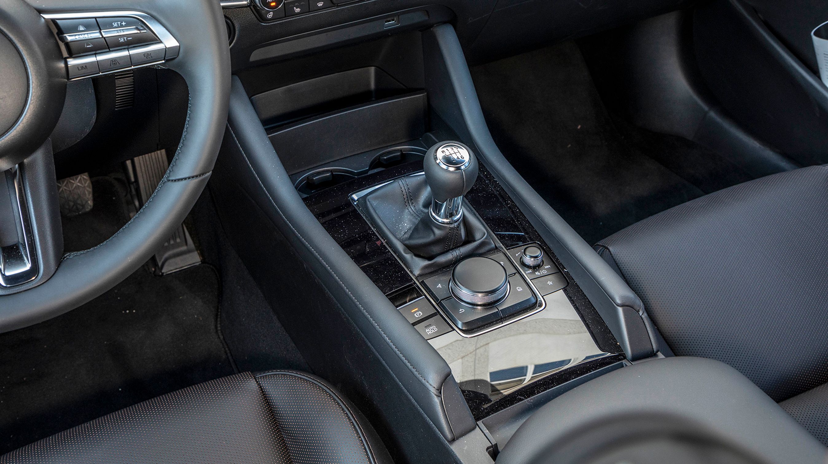 Bag gearstangen er den store drejeknap, der styrer alle funktionerne på den store skærm. To kopholdere er placeret foran gearstangen.