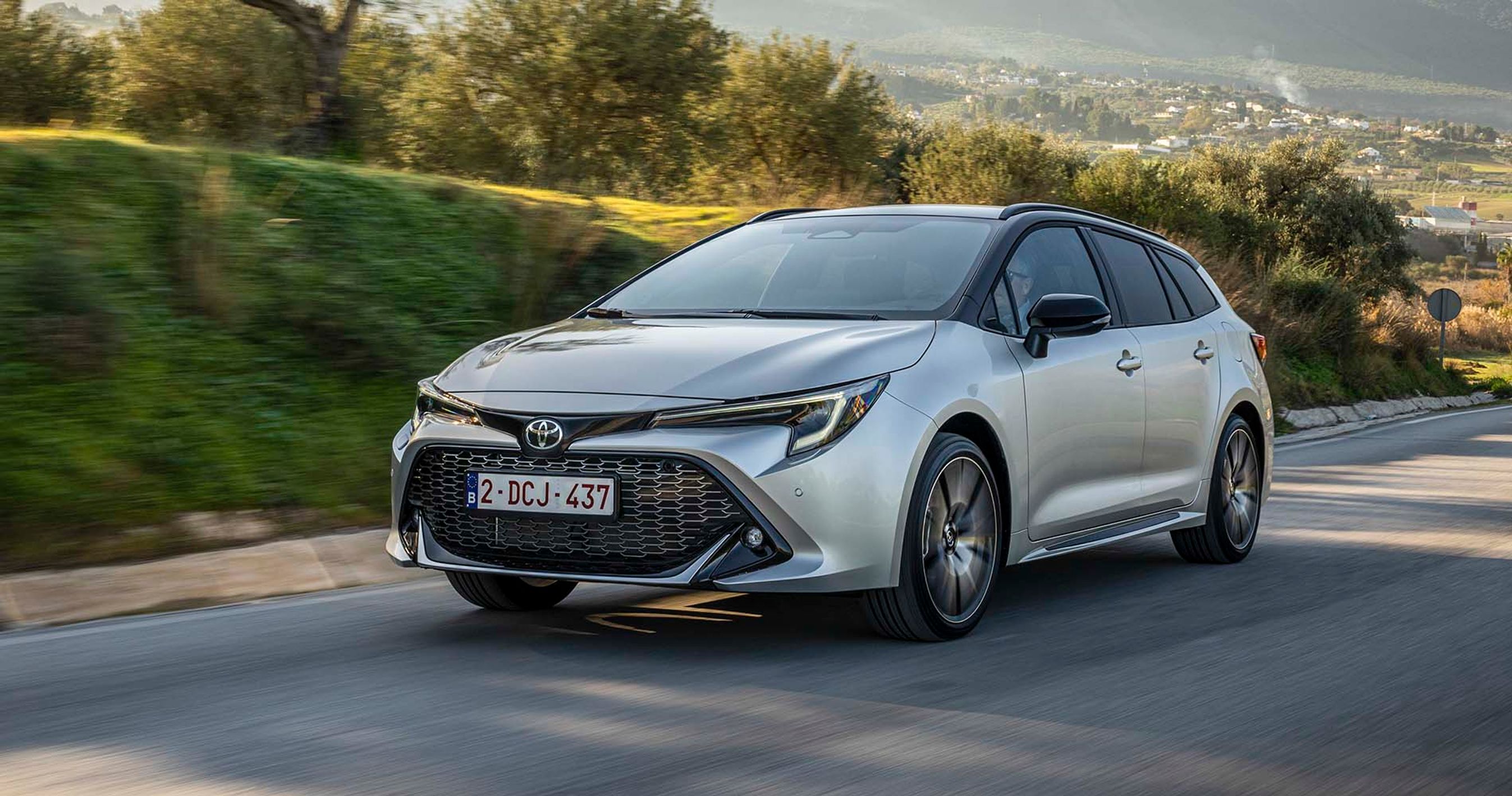 Toyota Corolla kører på landevej med træer i baggrunden