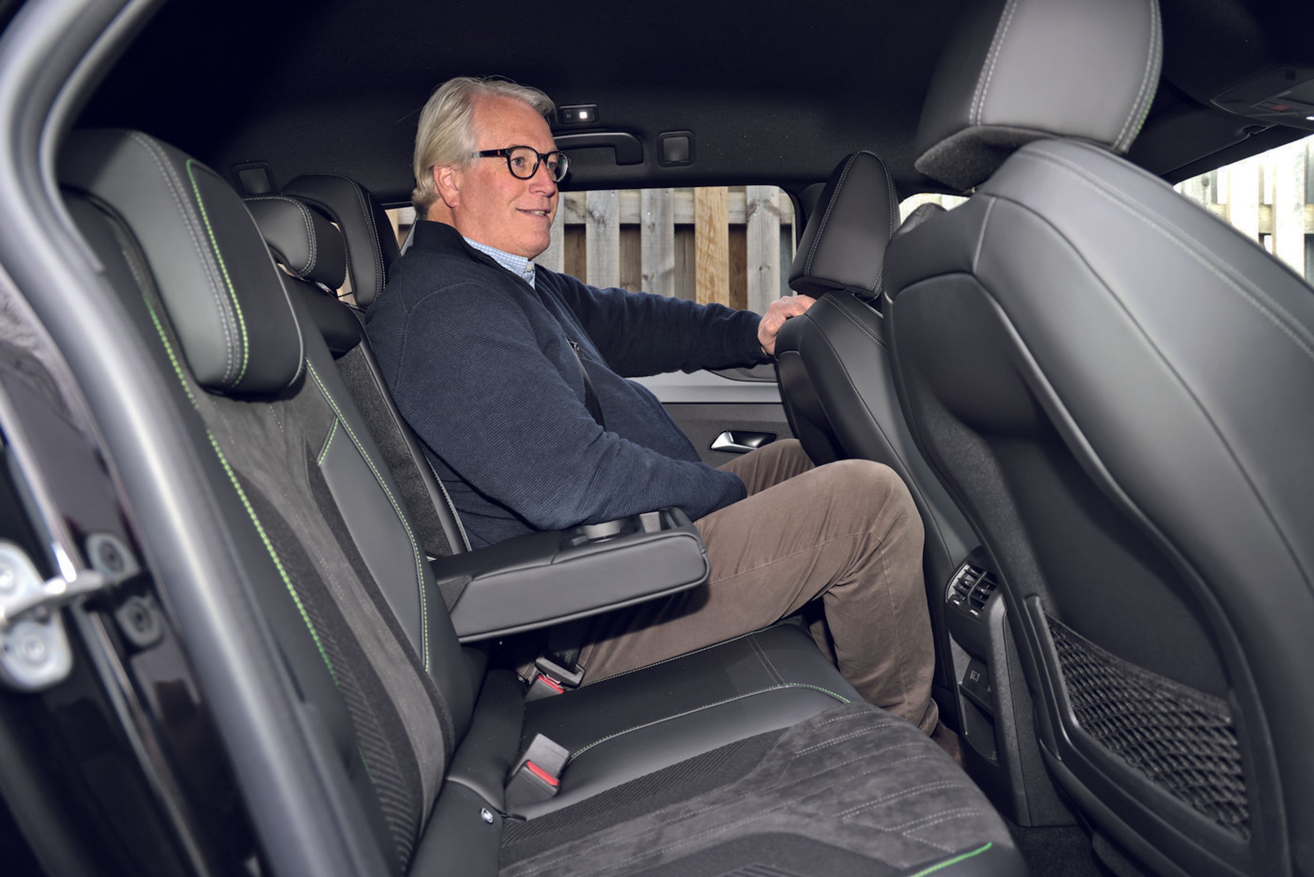 Person sidder på bagsædet i en Peugeot E-308 SW