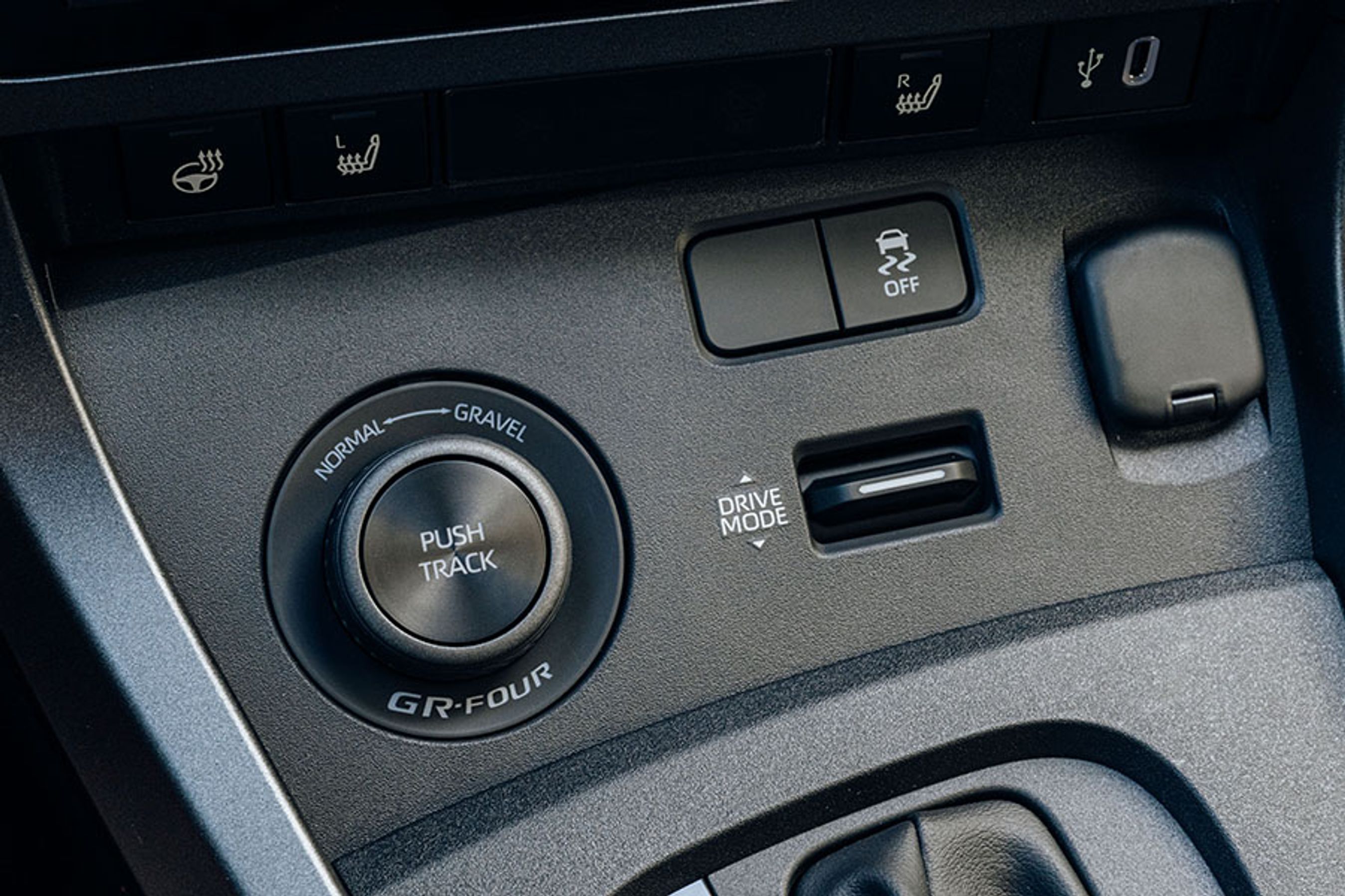 To knapper giver adgang til køreprogrammerne. Den venstre giver hurtig adgang til baneindstilling og grus, mens de almindelige køreprogrammer er til højre. Der skulle nok være byttet om, for den til venstre, som vil blive brugt langt mest, er svær at ramme for gearstangen.