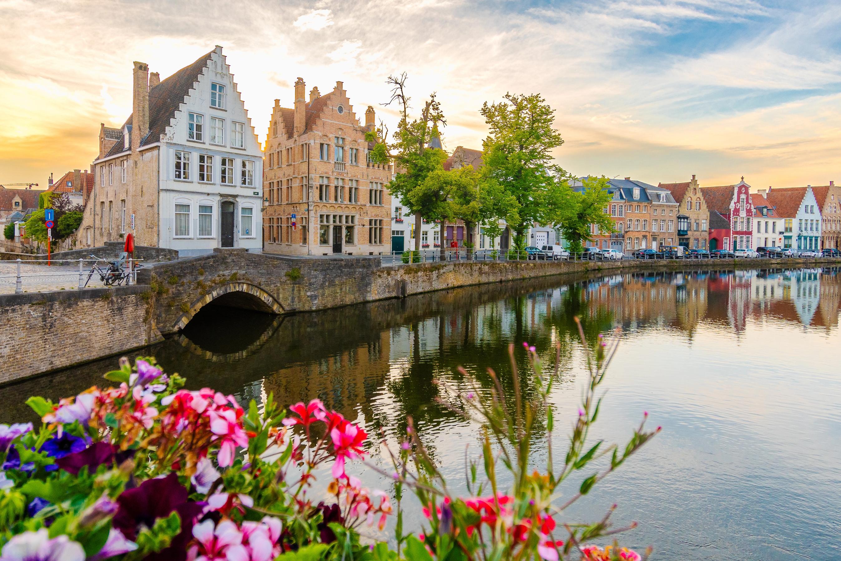 Kanal med historiske bygninger og bro i belgisk by.