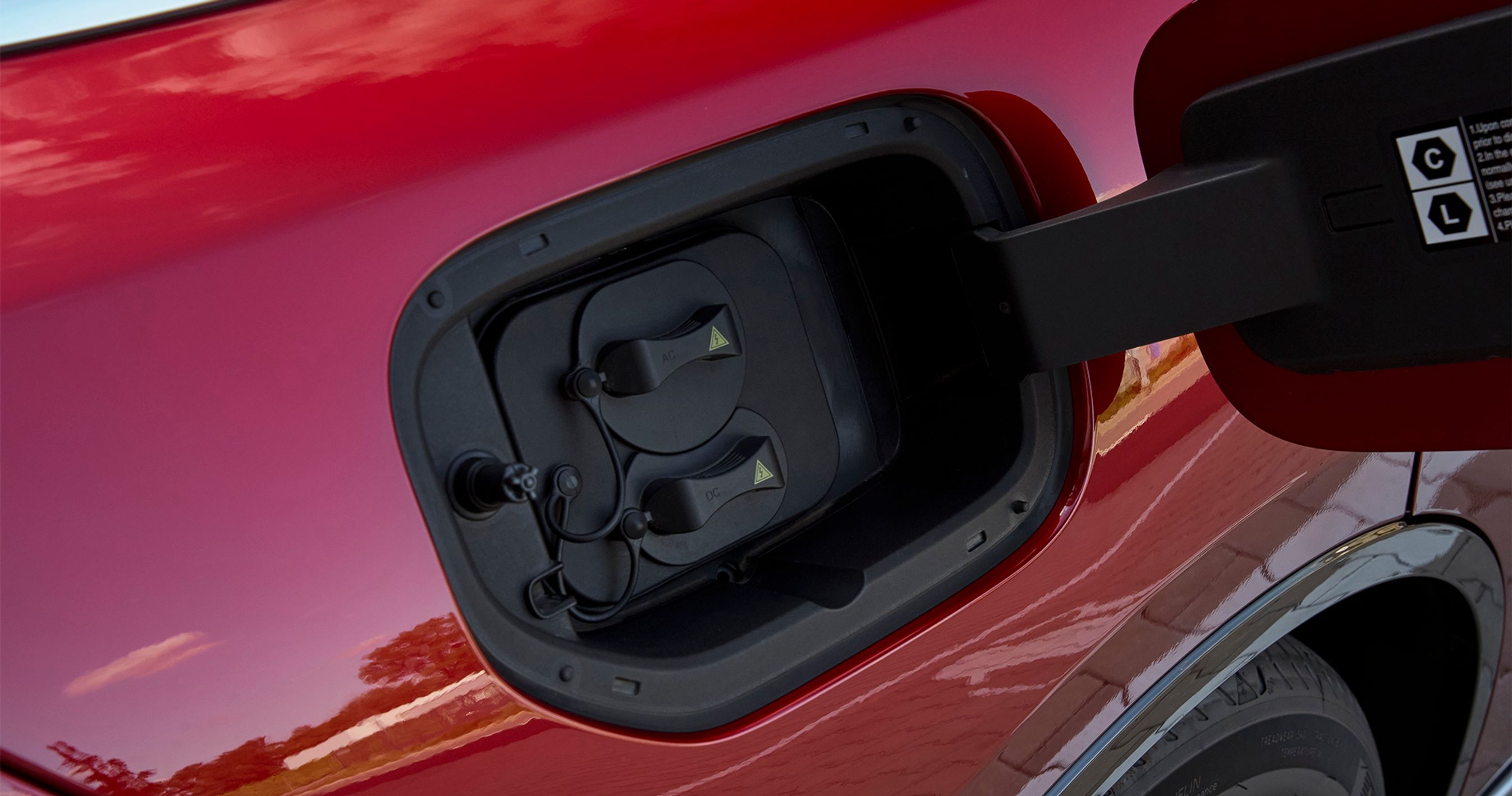 Ladestikket er placeret ved højre baghjul, og der er to gummipropper, som lidt besværligt skal fjernes før man kan lade bilen op. Med det lille batteri kan bilen lade med op til 165 kW, mens udgaven med det store batteri kun kan lades med op til 90 kW. Alle udgaver lader hjemme med op til 11 kW fra tre faser.