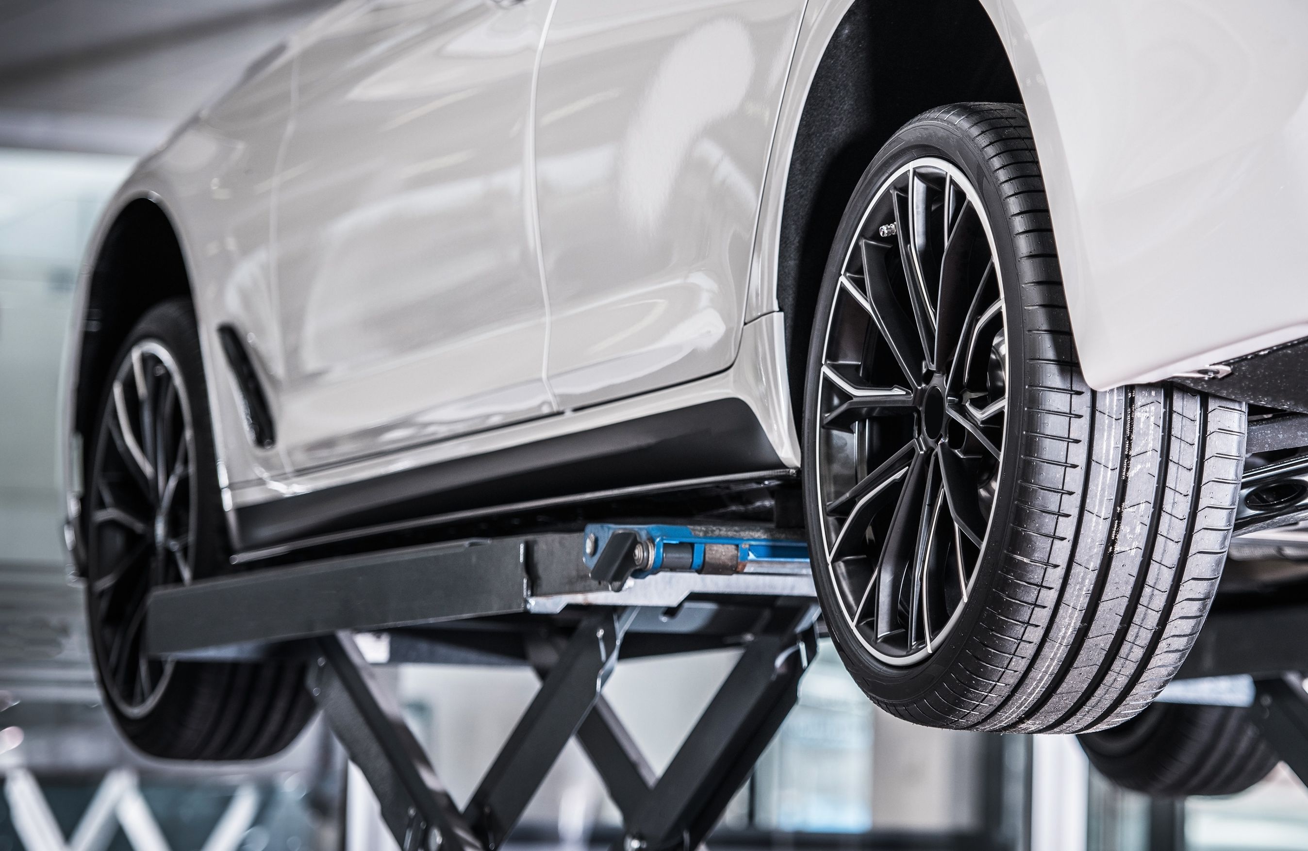 Bil holder på lift på et værksted.