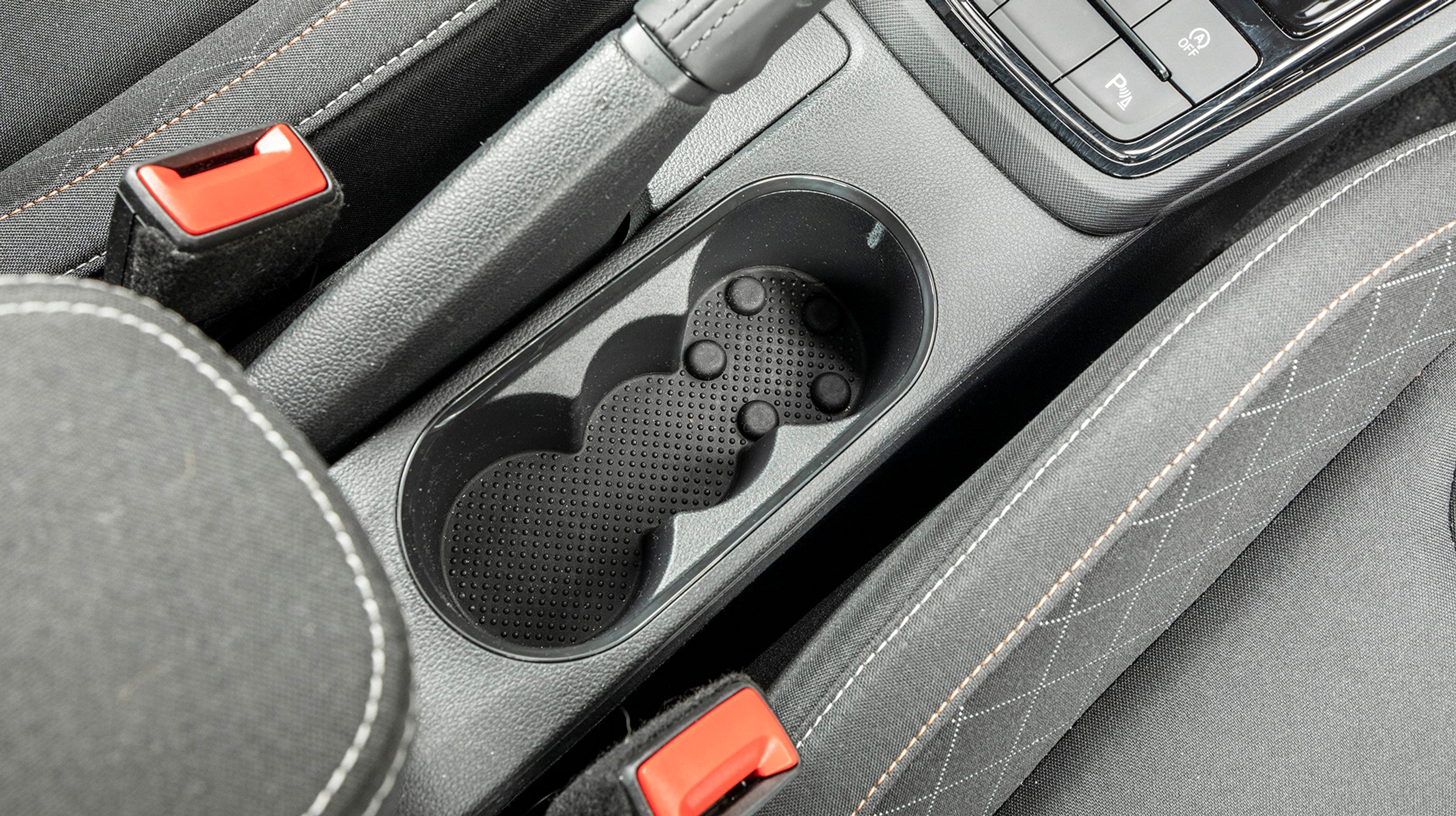 Kopholderne er godt placeret, men de er af den billige type, som ikke holder fast om drikkevarerne.