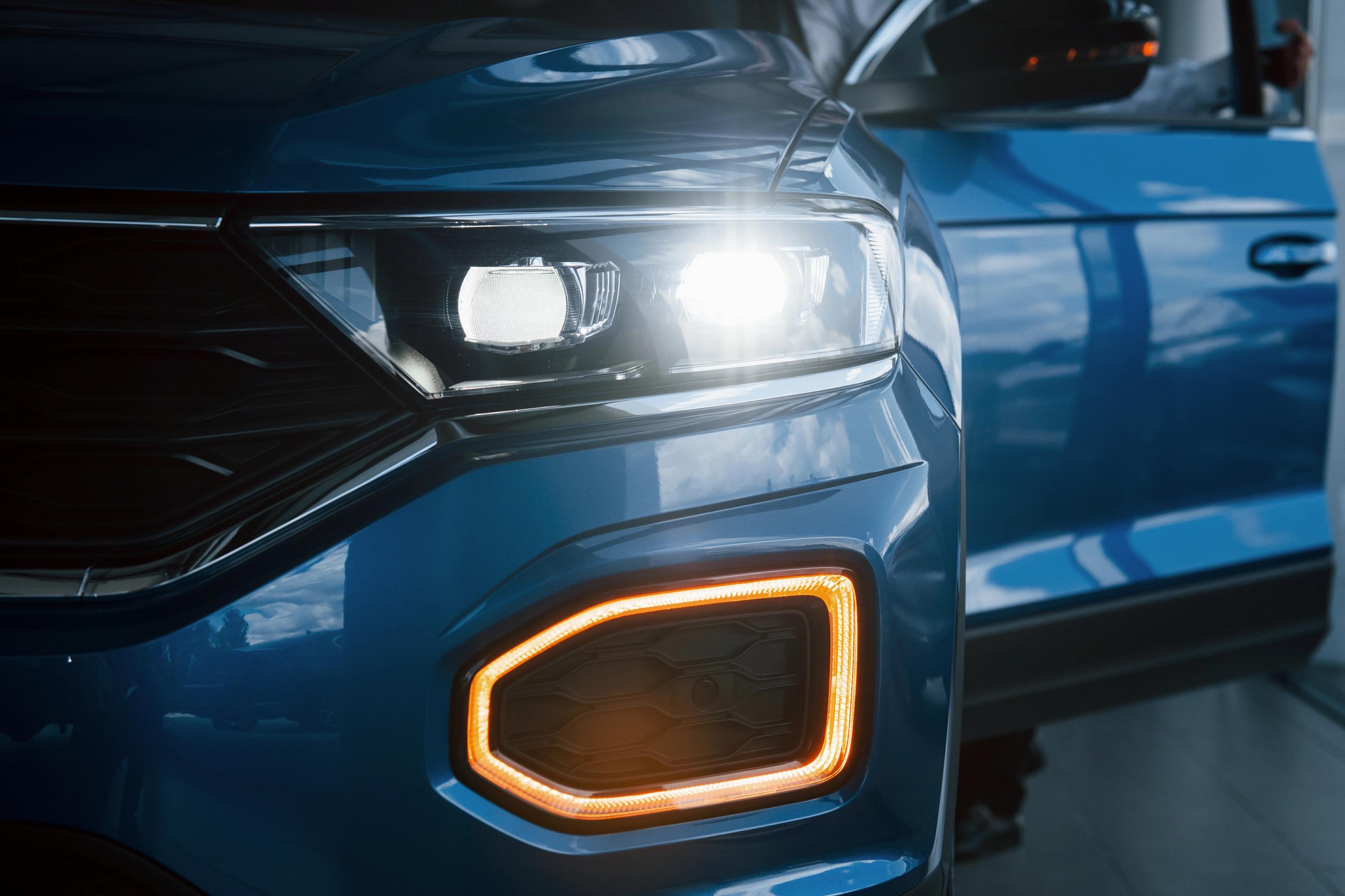 Fronten af en bil, hvor den ene forlygte lyser