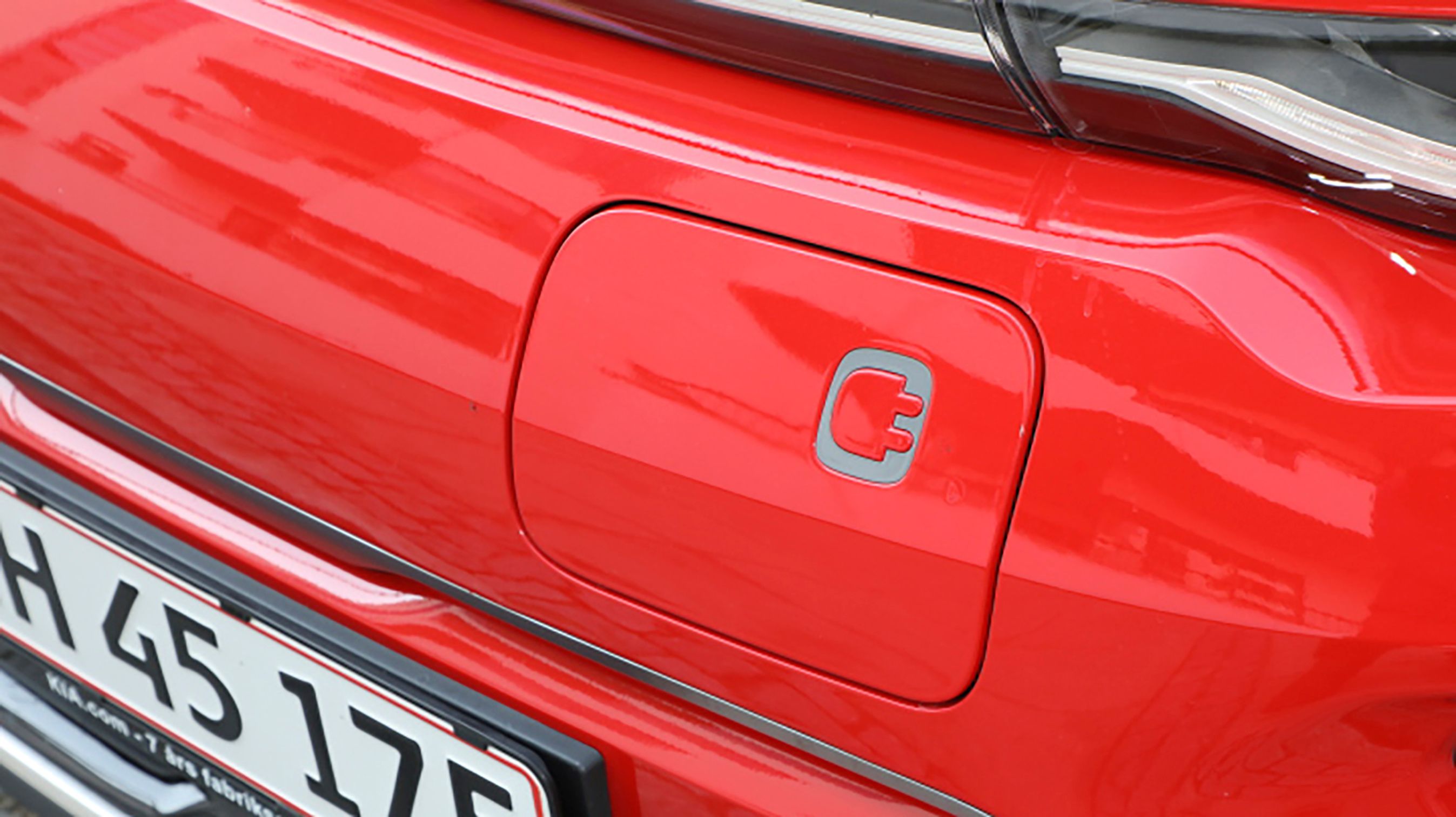 Ladestikket er placeret i fronten. Man kan ikke køre med bilen, hvis klappen ikke er lukket.