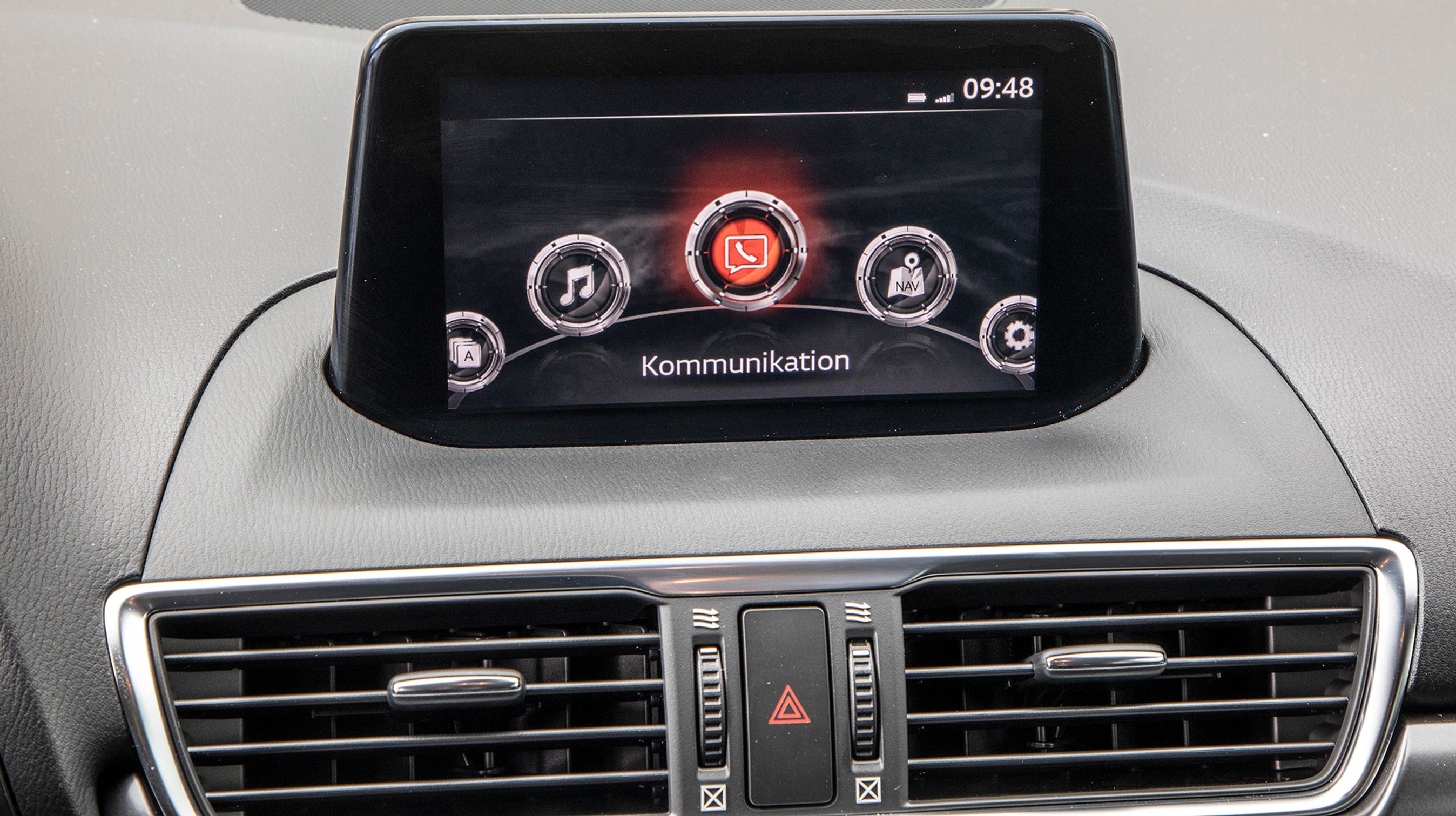 Skærmen er ret lille og er et af de områder, hvor man mærker alderen på Mazda 3. Når bilen holder stille er det en trykskærm, men under kørsel betjenes den via drejehjulet mellem forsæderne. Der er danske menuer.