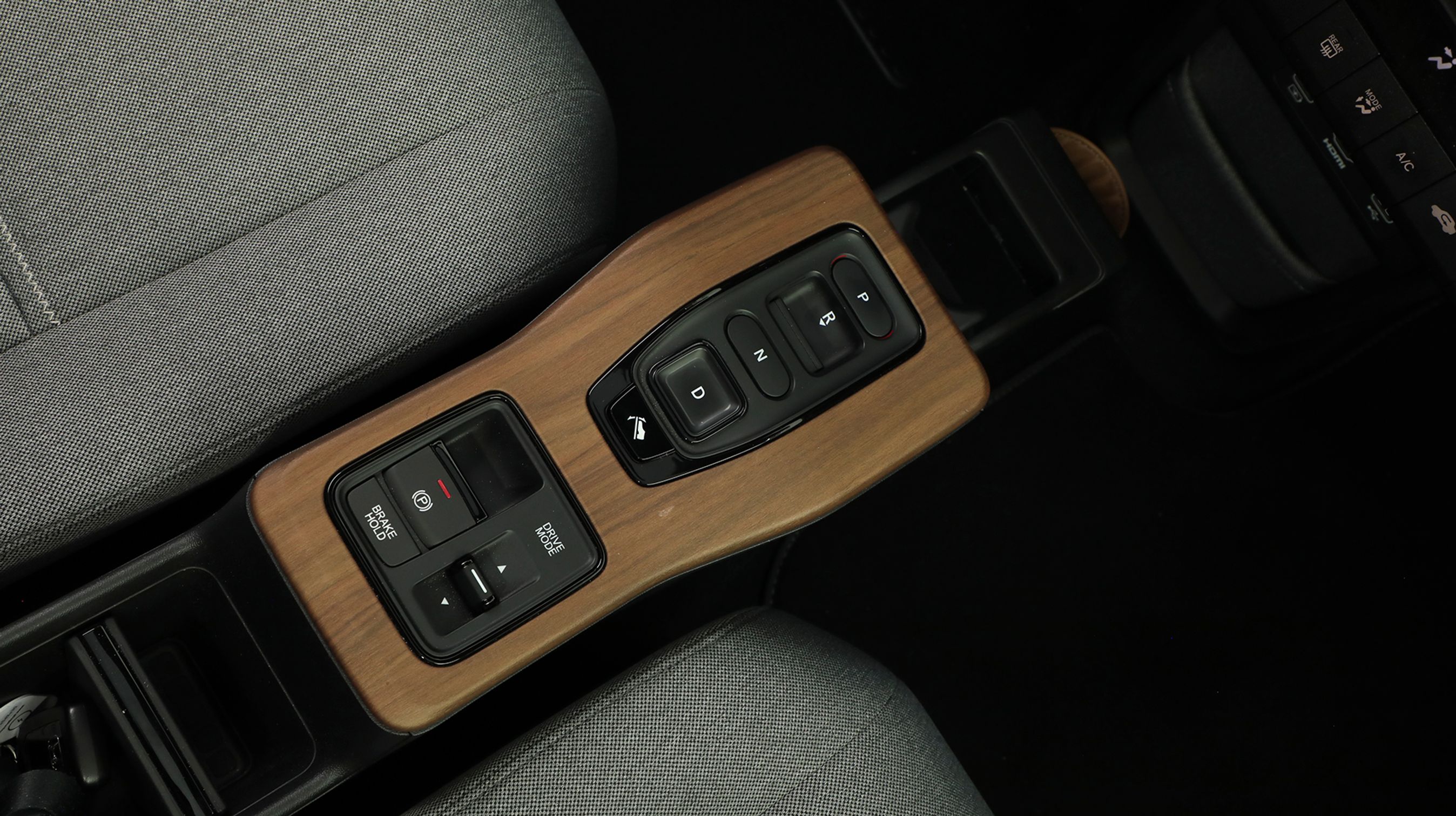 Mellem forsæderne styres kørselsretningen fra trykknapper. Det er let at bruge i hverdagen. Under ’D’ findes knappen, der aktiverer ’One-Pedal-Drive’, så man kan køre bilen med blot én fod på speederen – når man slipper, bremser den selv via elmotoren.