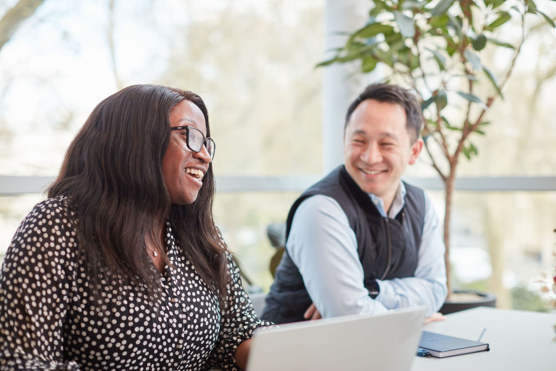 A woman and man in a meeting with a laptop in the foreground