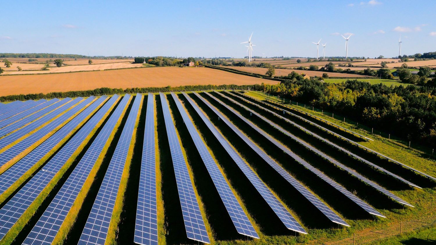 Wind turbines and a solar farm at sunset