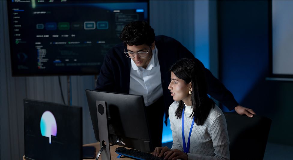 Two people talking in front of the workstation