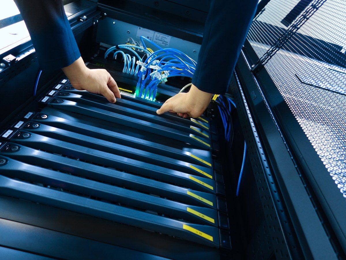 Technician hands installing server hardware in rack