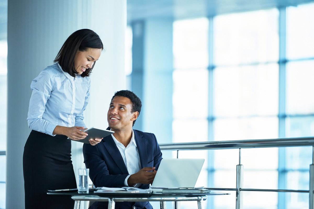 Two professionals sharing tablet in office