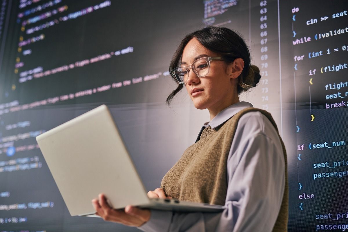 Developer woman with laptop in front of code