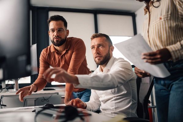 Three colleagues reviewing at office screen