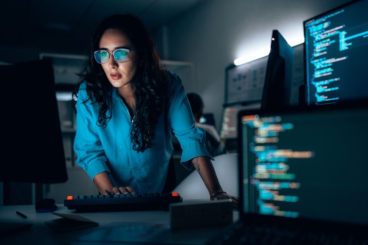 Woman looking at screen in dark room