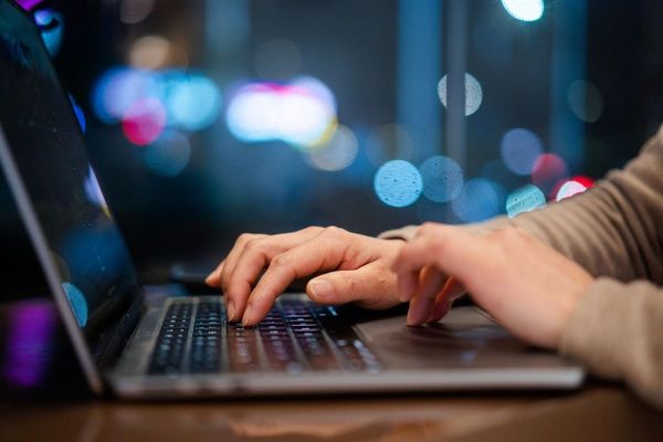 hands typing on laptop keyboard