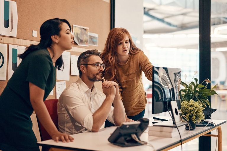 Three workers looking at the monitor
