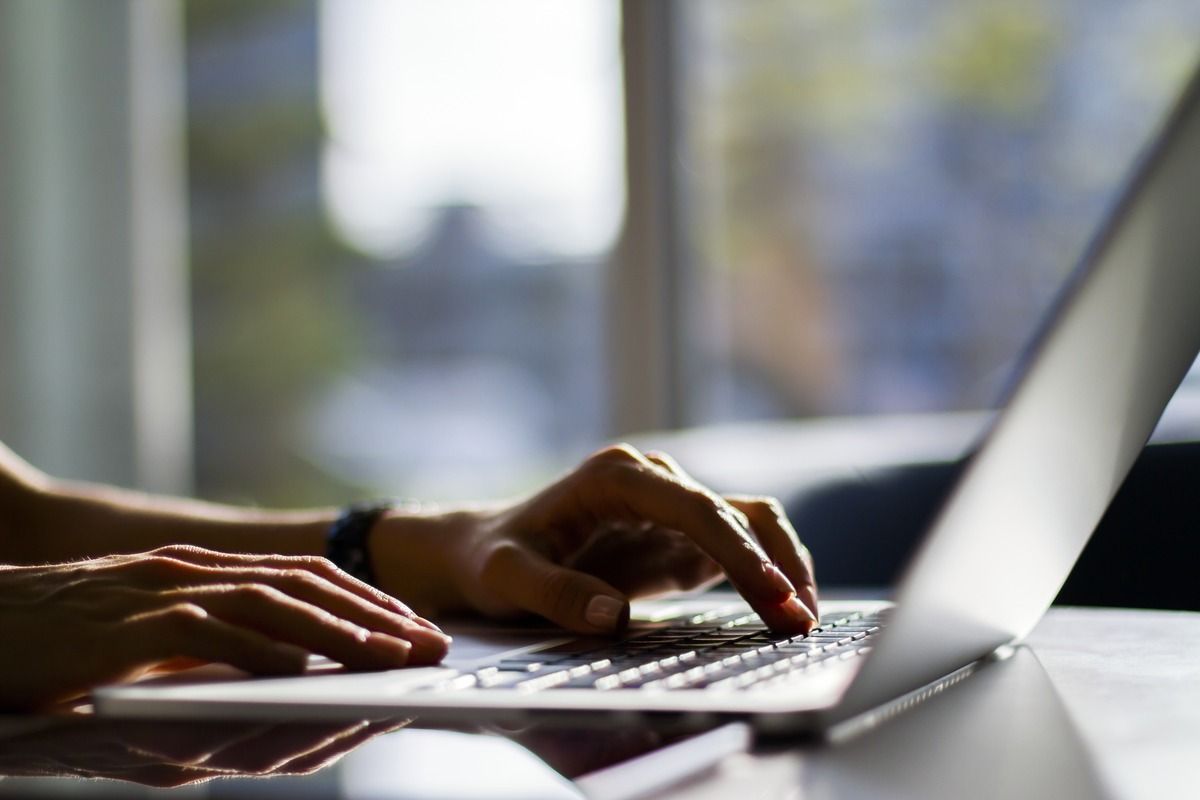 hands typing on laptop