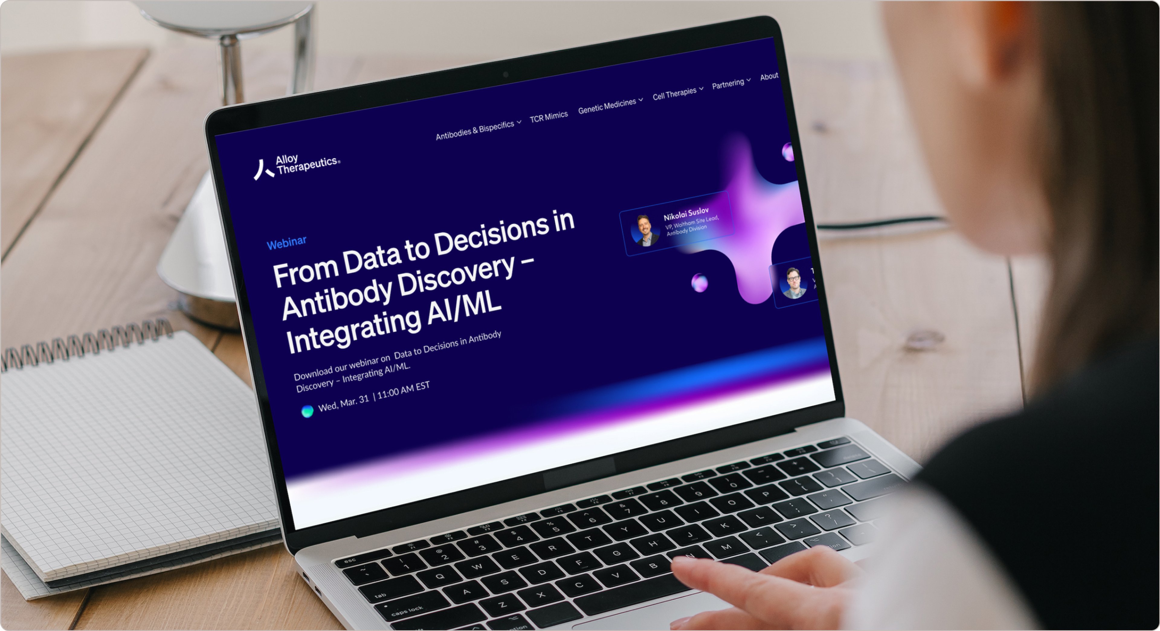 An Alloy Therapeutics webinar page, "From Data to Decisions in Antibody Discovery", open on a laptop