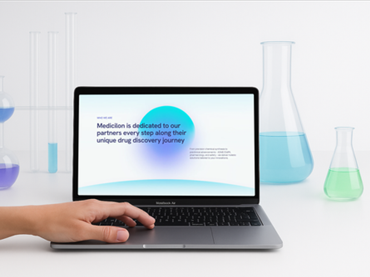 The Medicilon website on a laptop among lab glassware