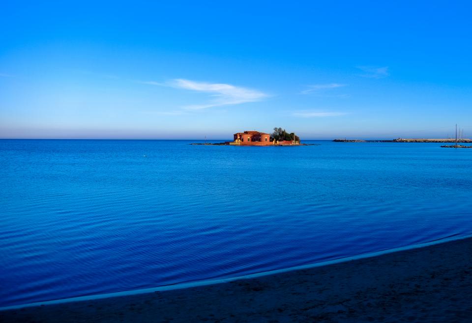 Still water and a pastel coastline.