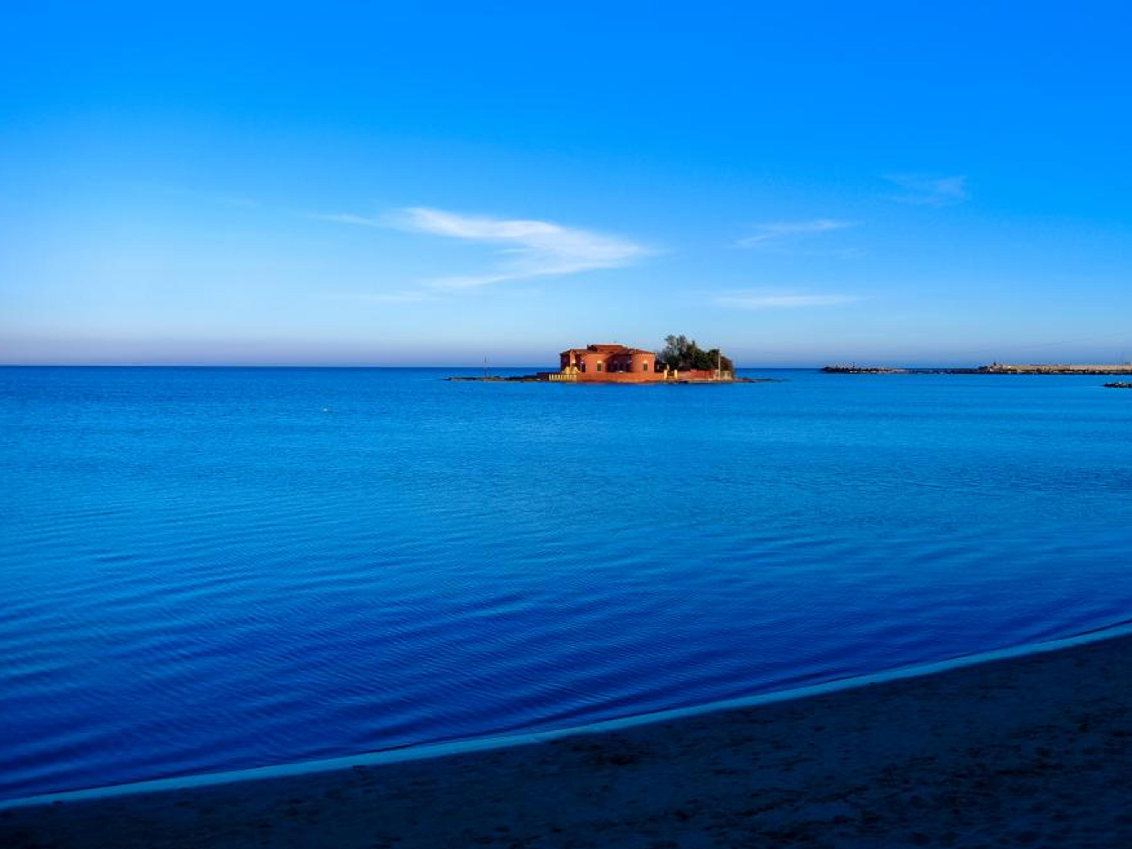 Still water and a pastel coastline.