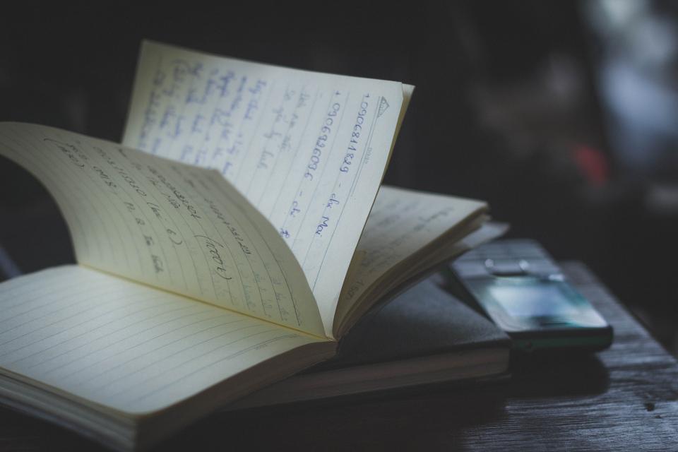 An open notebook and pen on a desk.