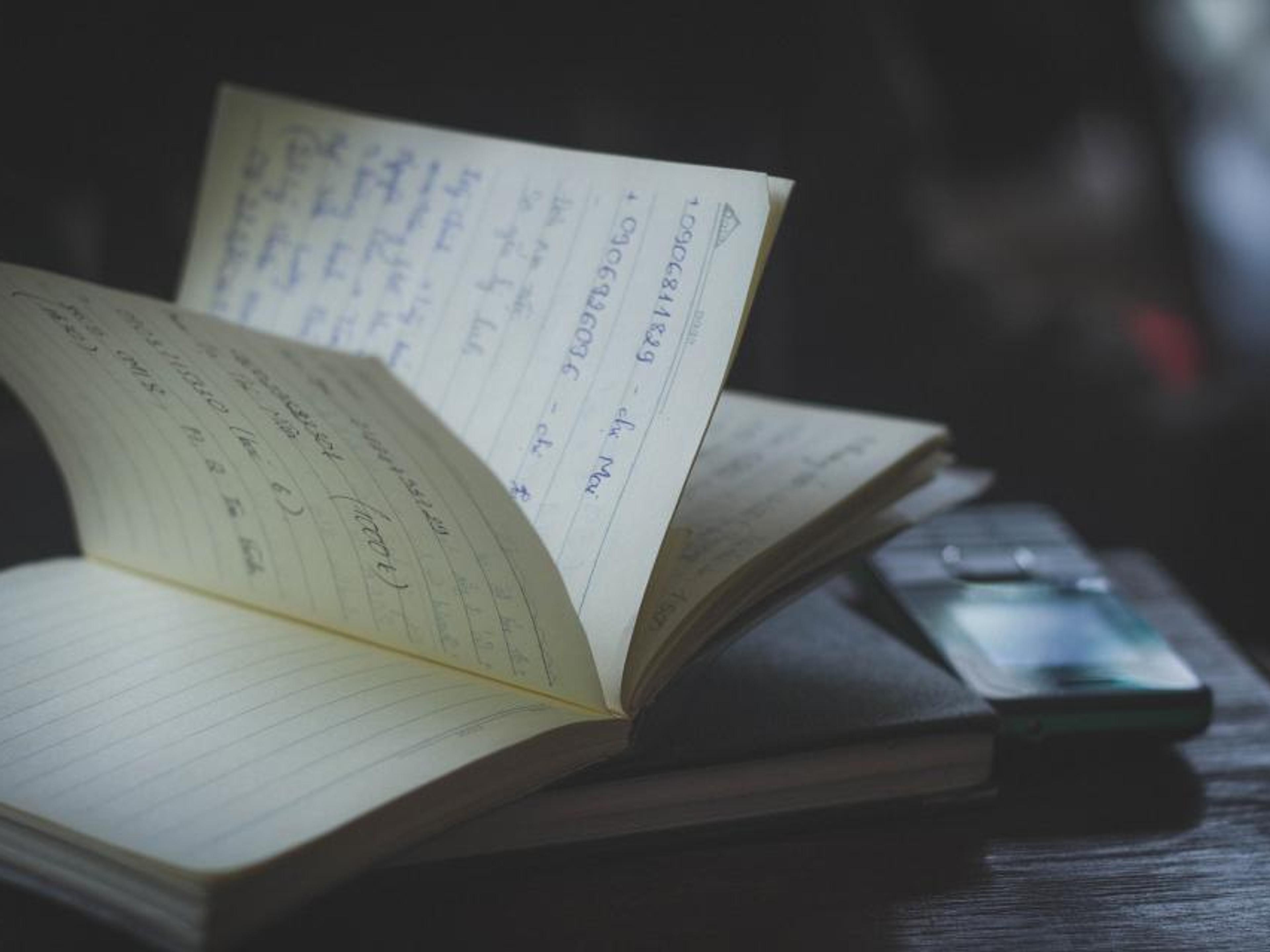 An open notebook and pen on a desk.