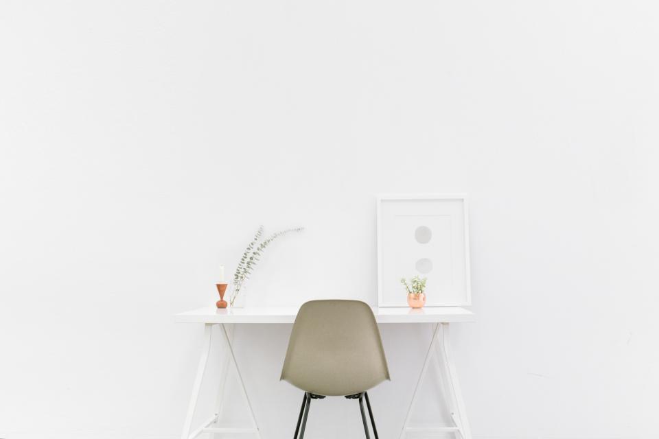 A calm, tidy office desk with a notebook and coffee.
