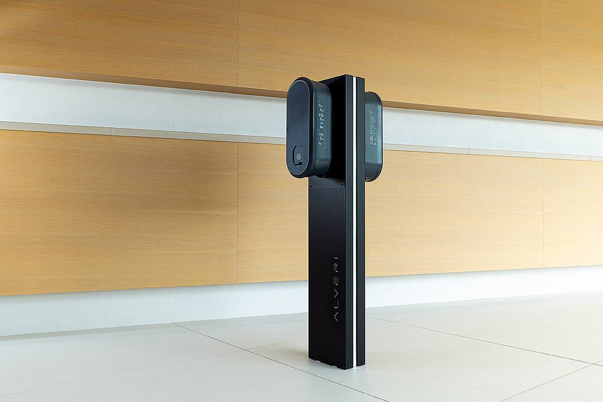 Black Alveri wallbox on a stand in front of a wood-panelled wall