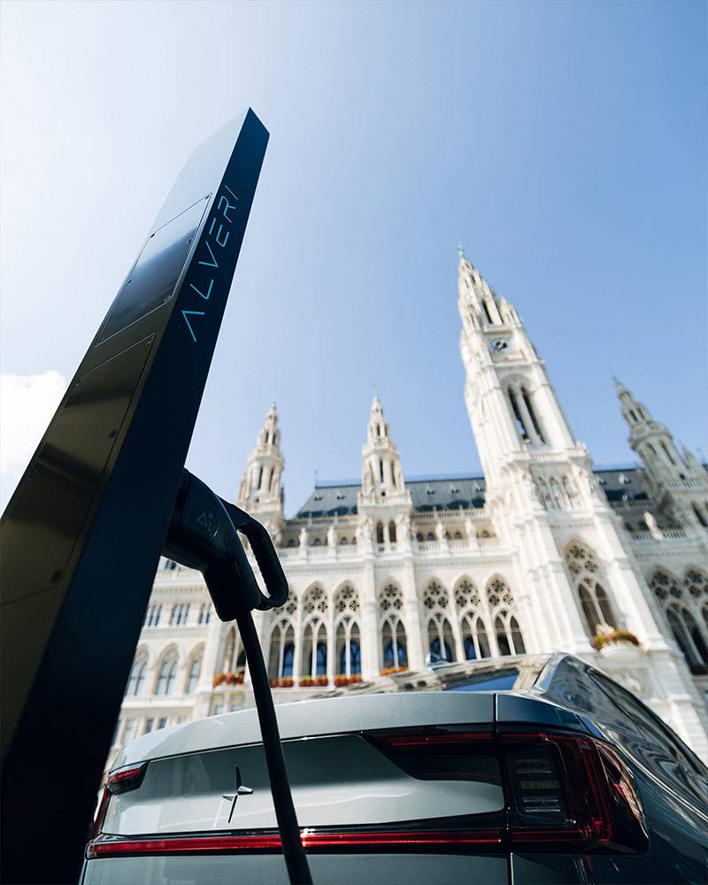 Alveri charging station and a car in front of a neo-Gothic building, seen from below