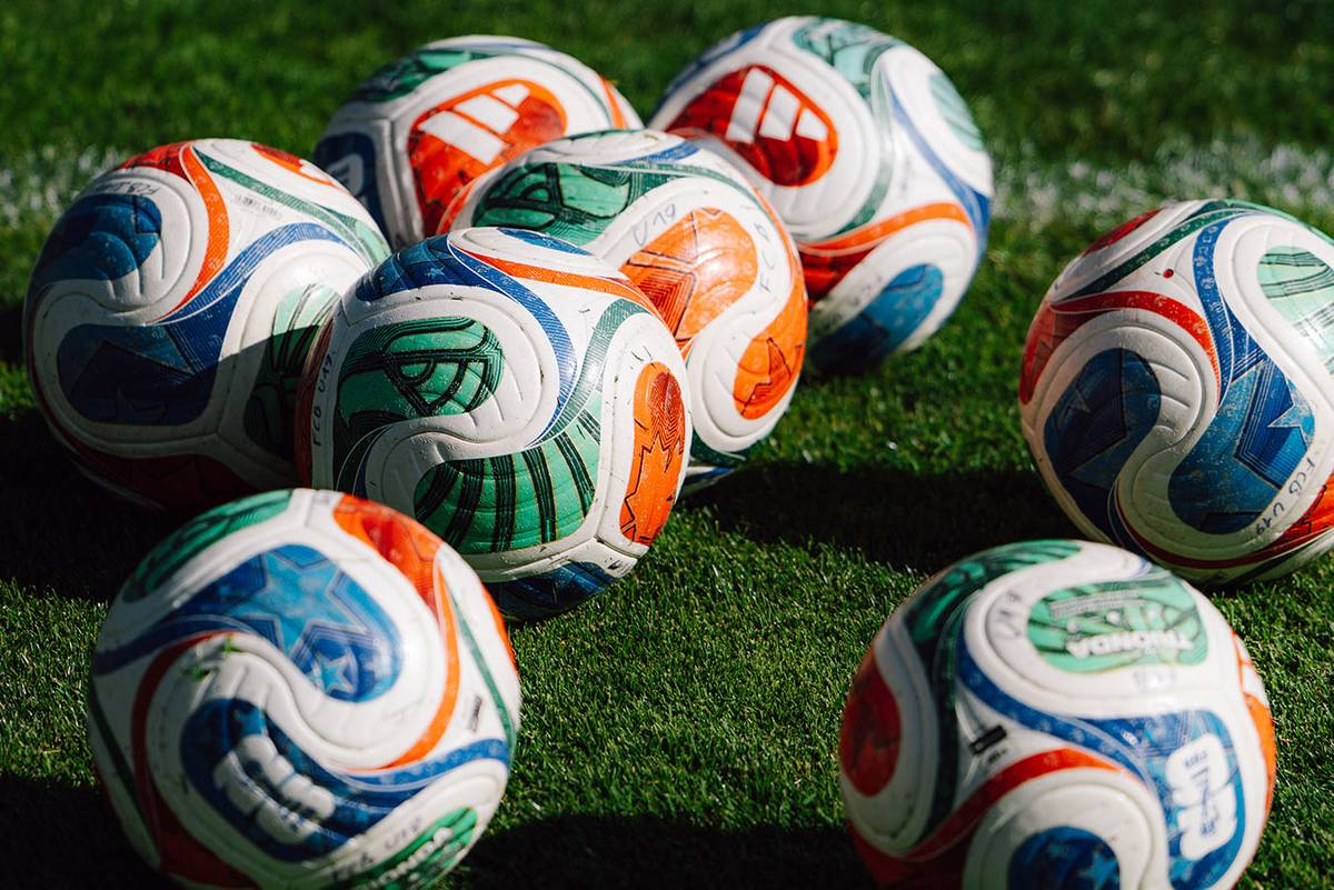 Spielbälle liegen in der Sonne auf dem Rasen