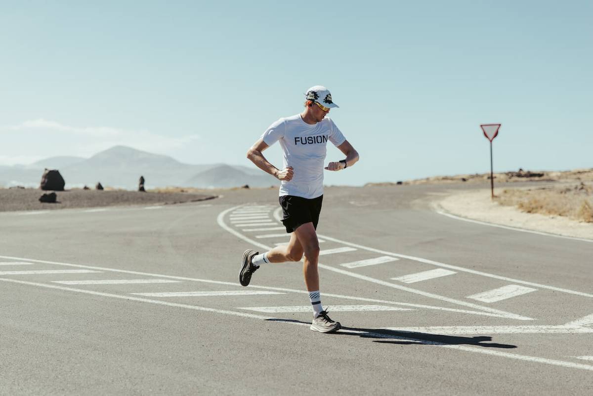 Runner checking his watch while crossing an empty junction