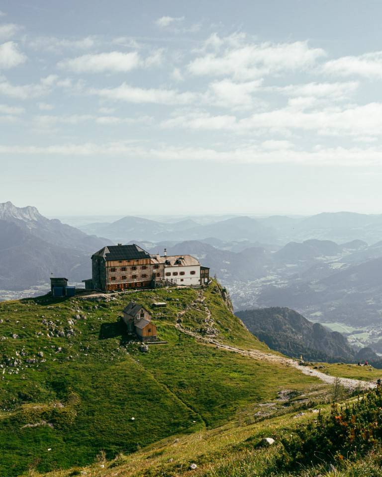 Mountain hut on a green ridge high above the valley