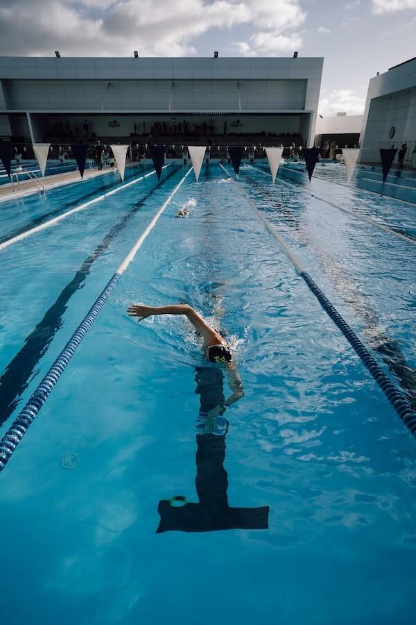 Swimmer doing front crawl in an outdoor pool, seen from above