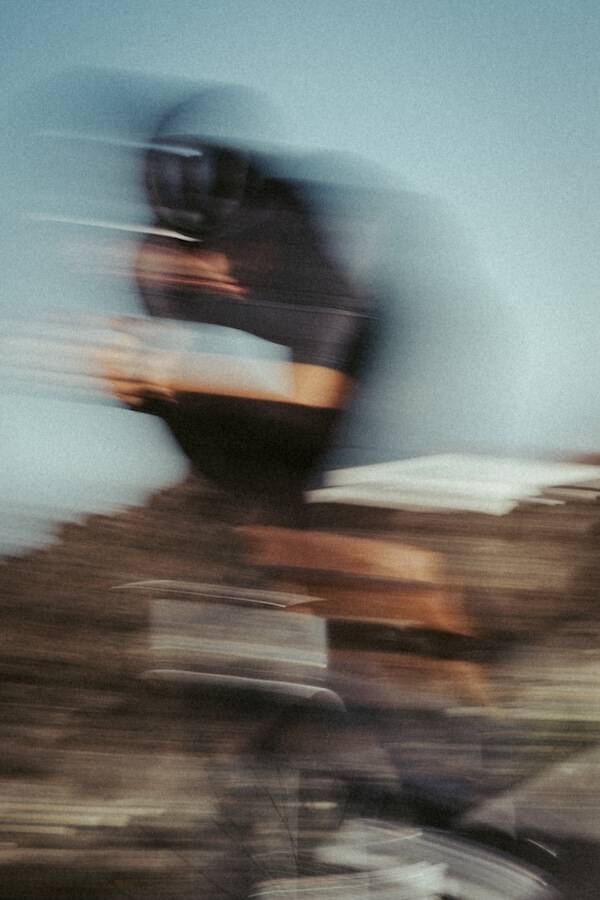 Cyclist in a time-trial position, heavily blurred by motion