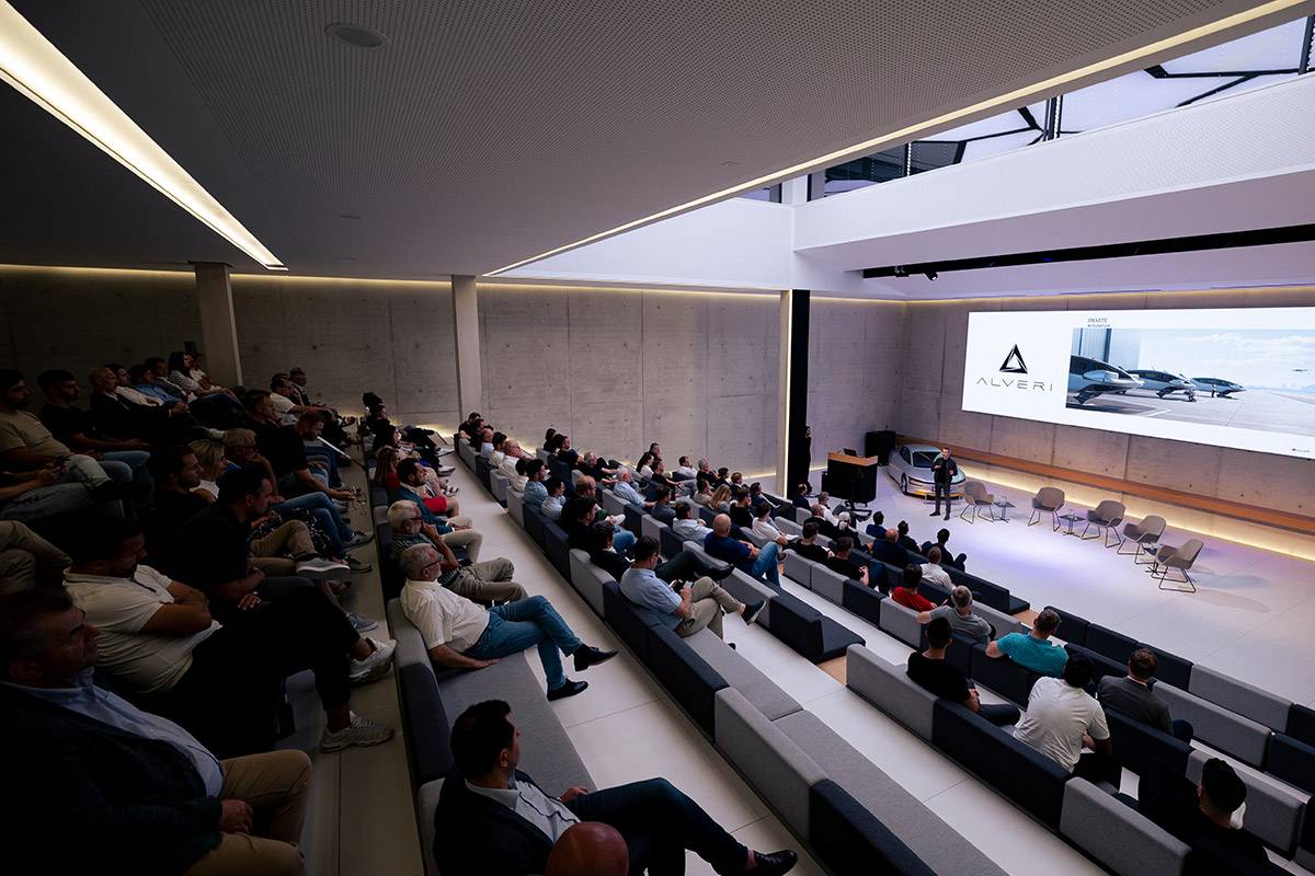 Full auditorium during the Alveri presentation, the logo on the screen