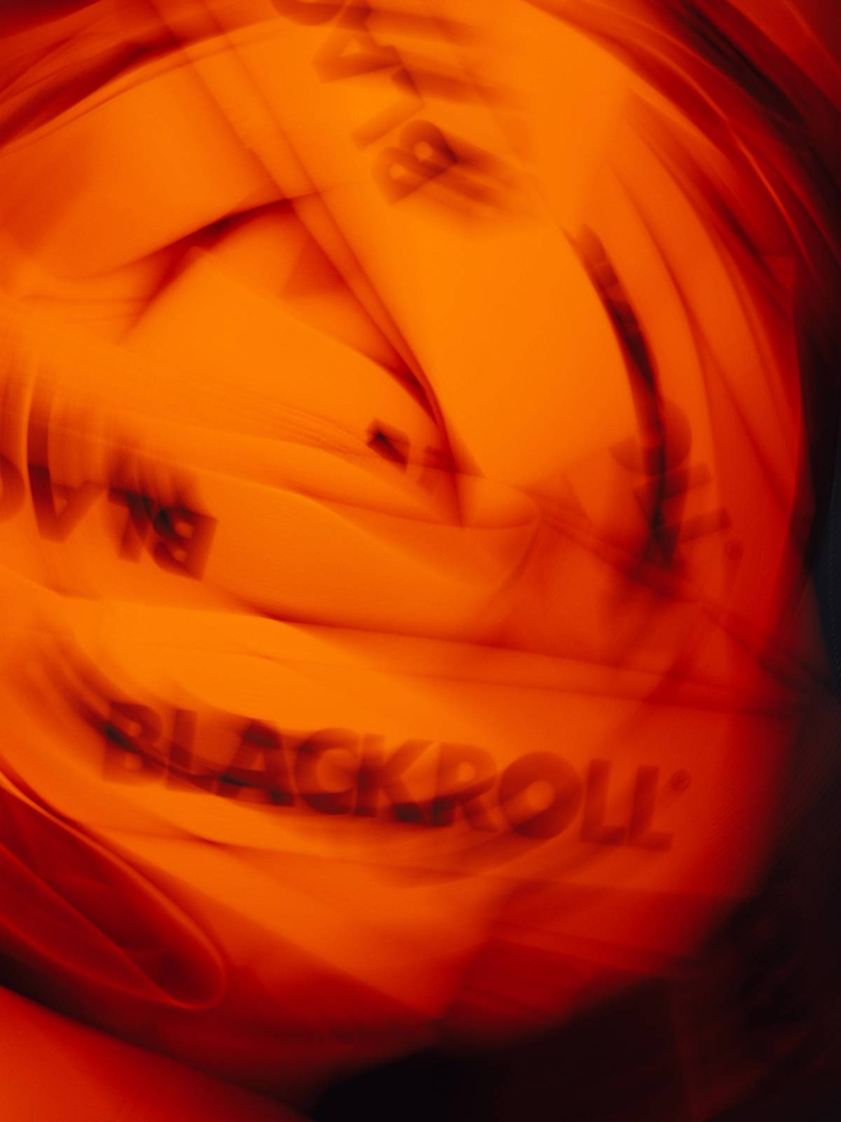 Blurred close-up of film production gear and coiled cables under intense orange-red lighting.