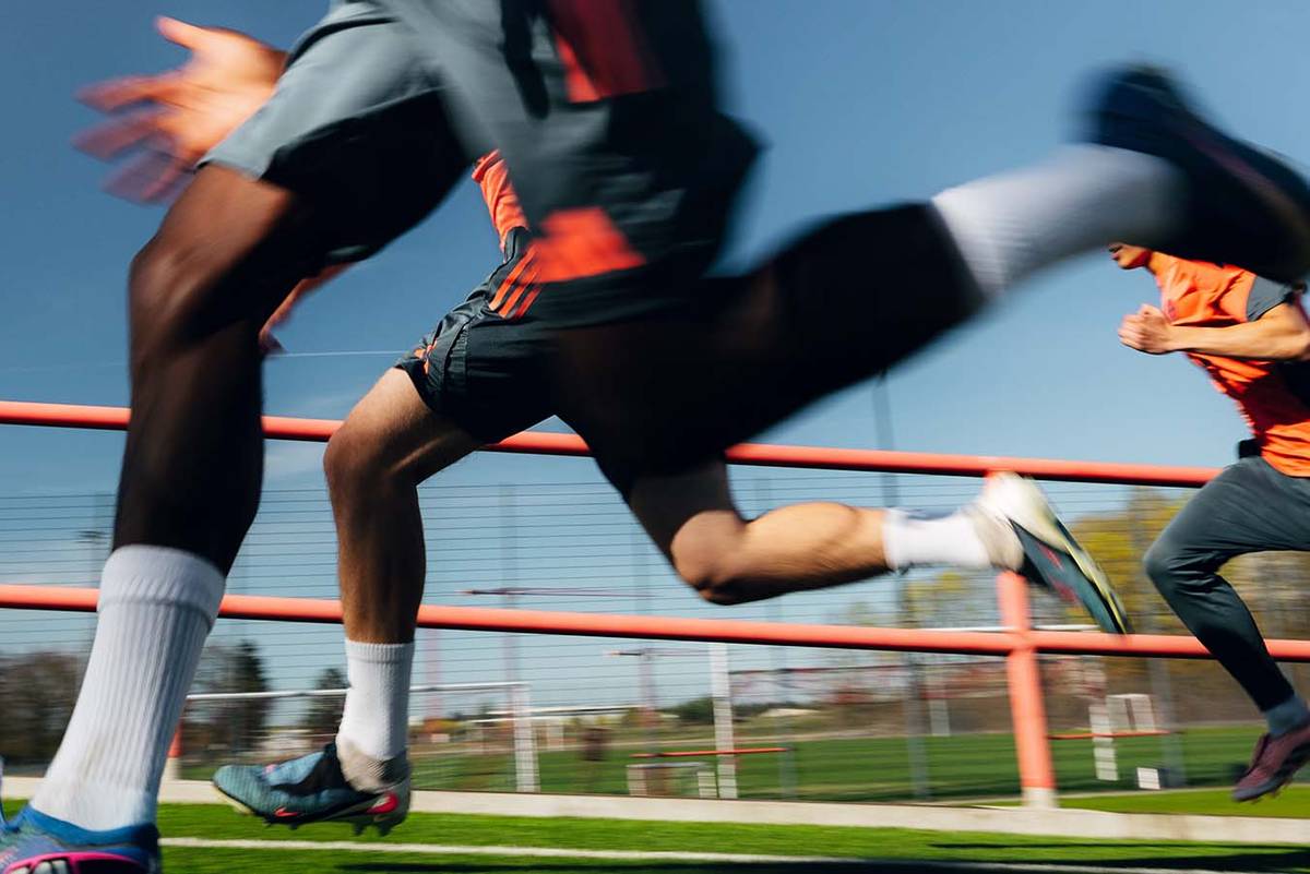 Spieler sprinten an der Kamera vorbei, Beine und Schuhe in Bewegungsunschärfe