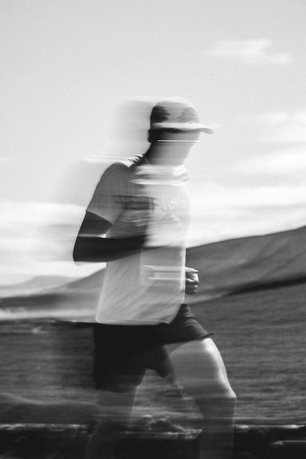 Black-and-white multiple exposure of a runner in a cap