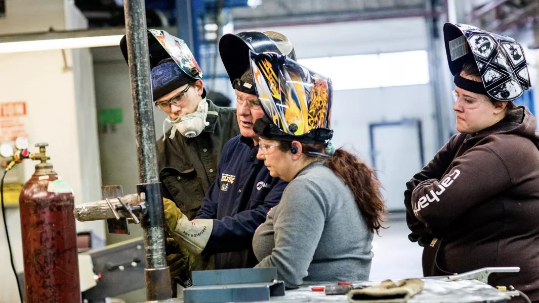 Instructor guiding students during hands on welding instruction
