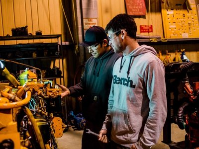 Industrial Mechanic Millwright apprentices inspecting a transport truck engine
