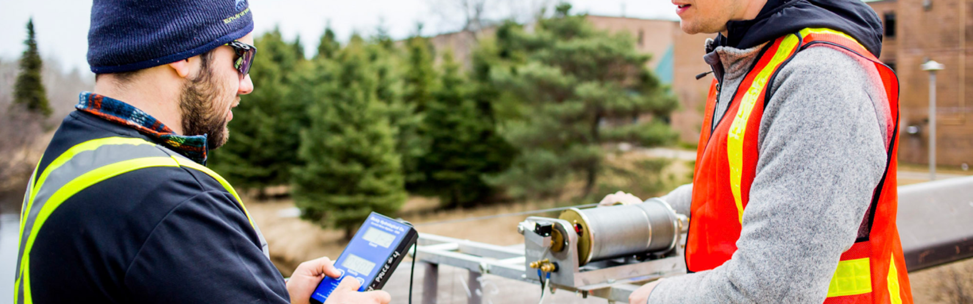 Students conducting environmental monitoring with field equipment at an outdoor testing site