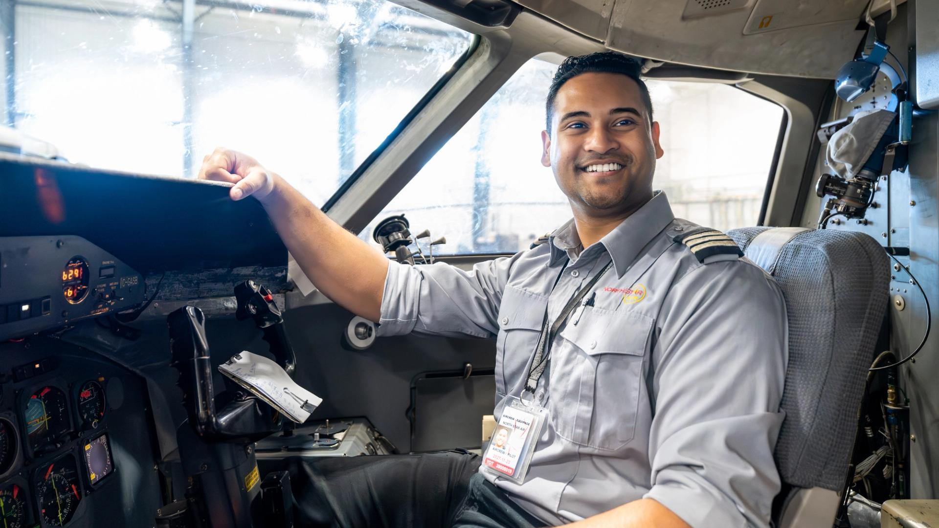 Aviation Flight Management graduate in cockpit of Dash 8, representing path to first officer with North Star Air.