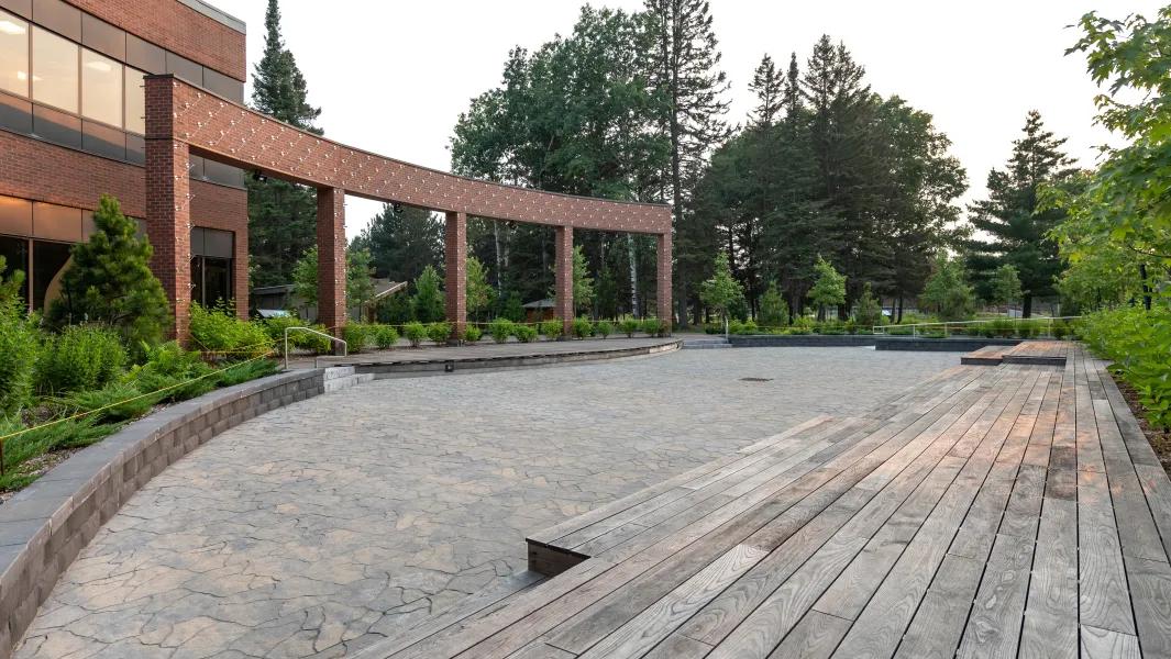 Empty outdoor plaza with tiered seating beside a campus building