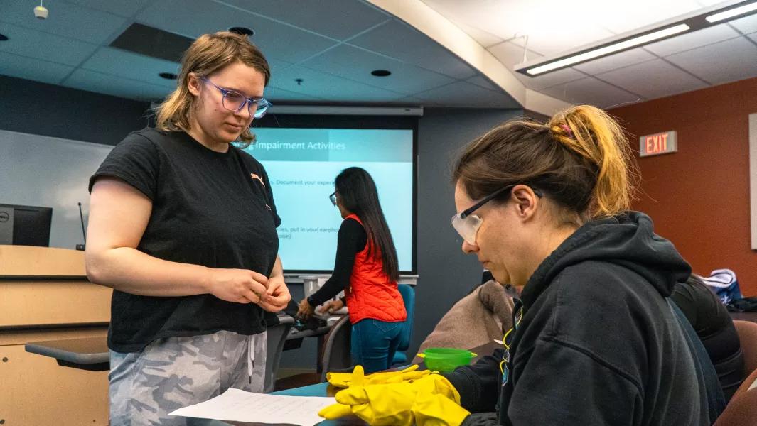 Students participating in a classroom activity involving gloves and written instructions