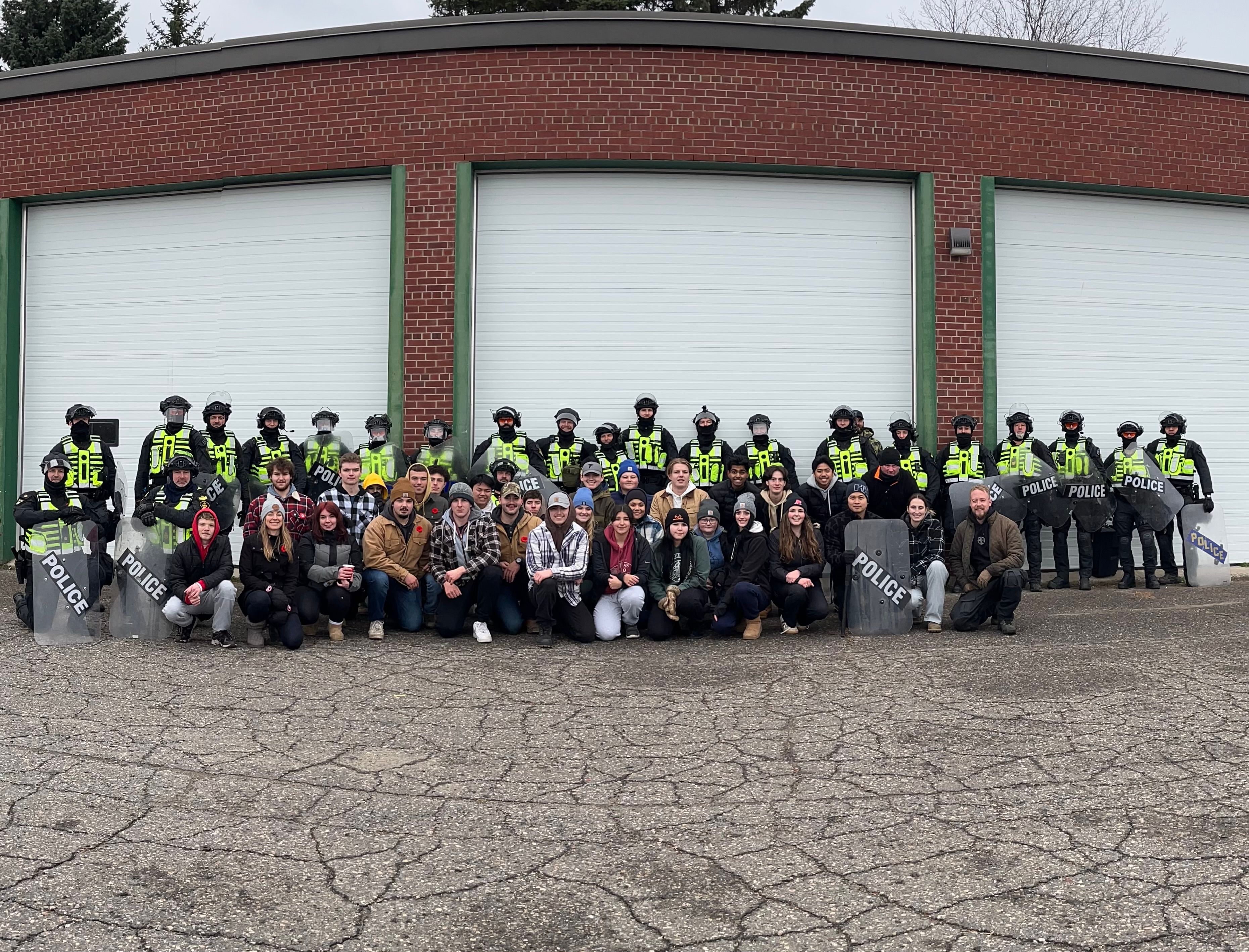 Police and students pose together during a public order training exercise
