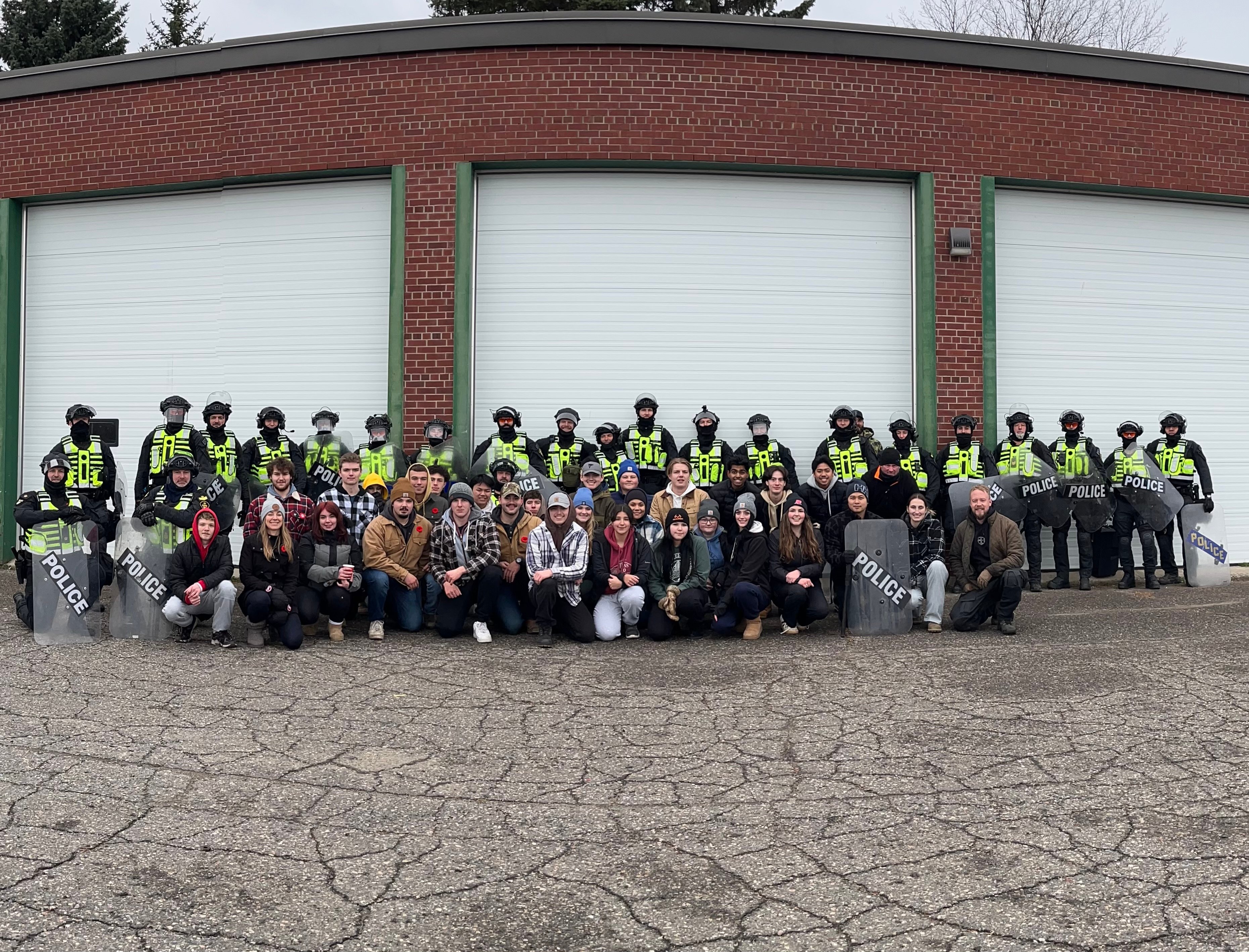 Police and students pose together during a public order training exercise